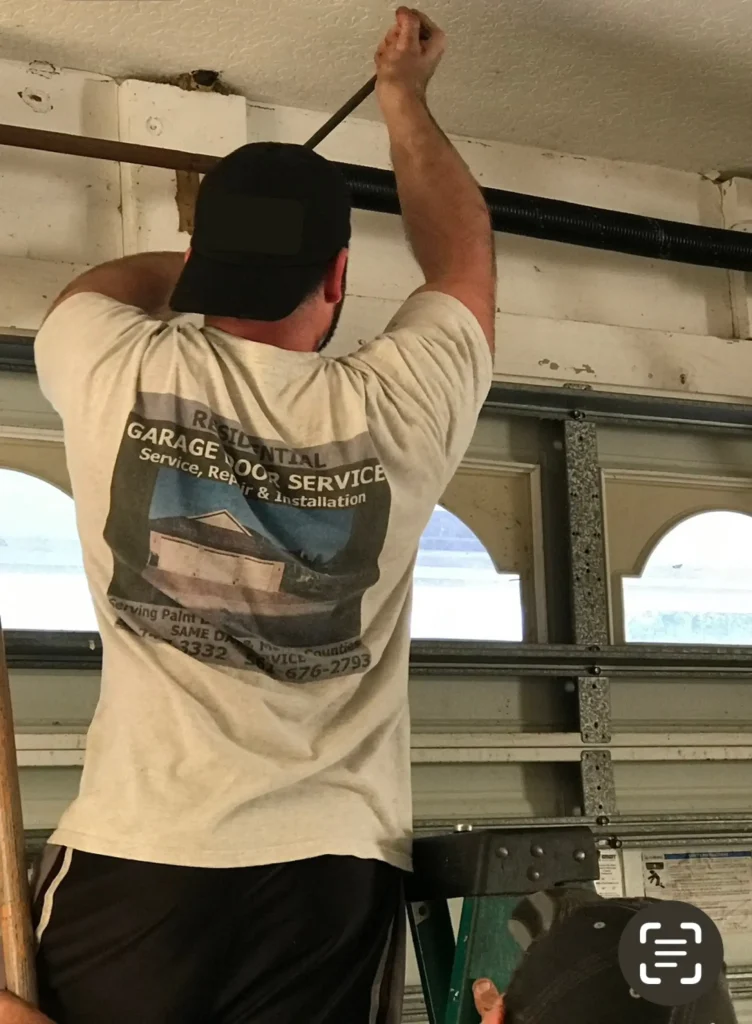 Technician calibrating a residential garage door system during a service optimization project