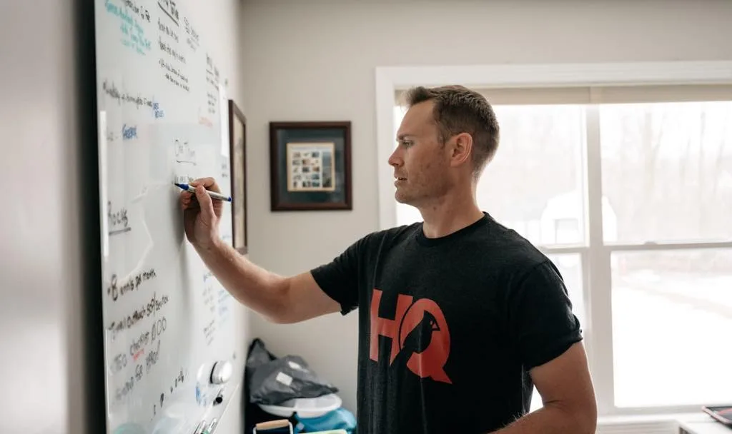 Business owner sketching a growth plan on a whiteboard